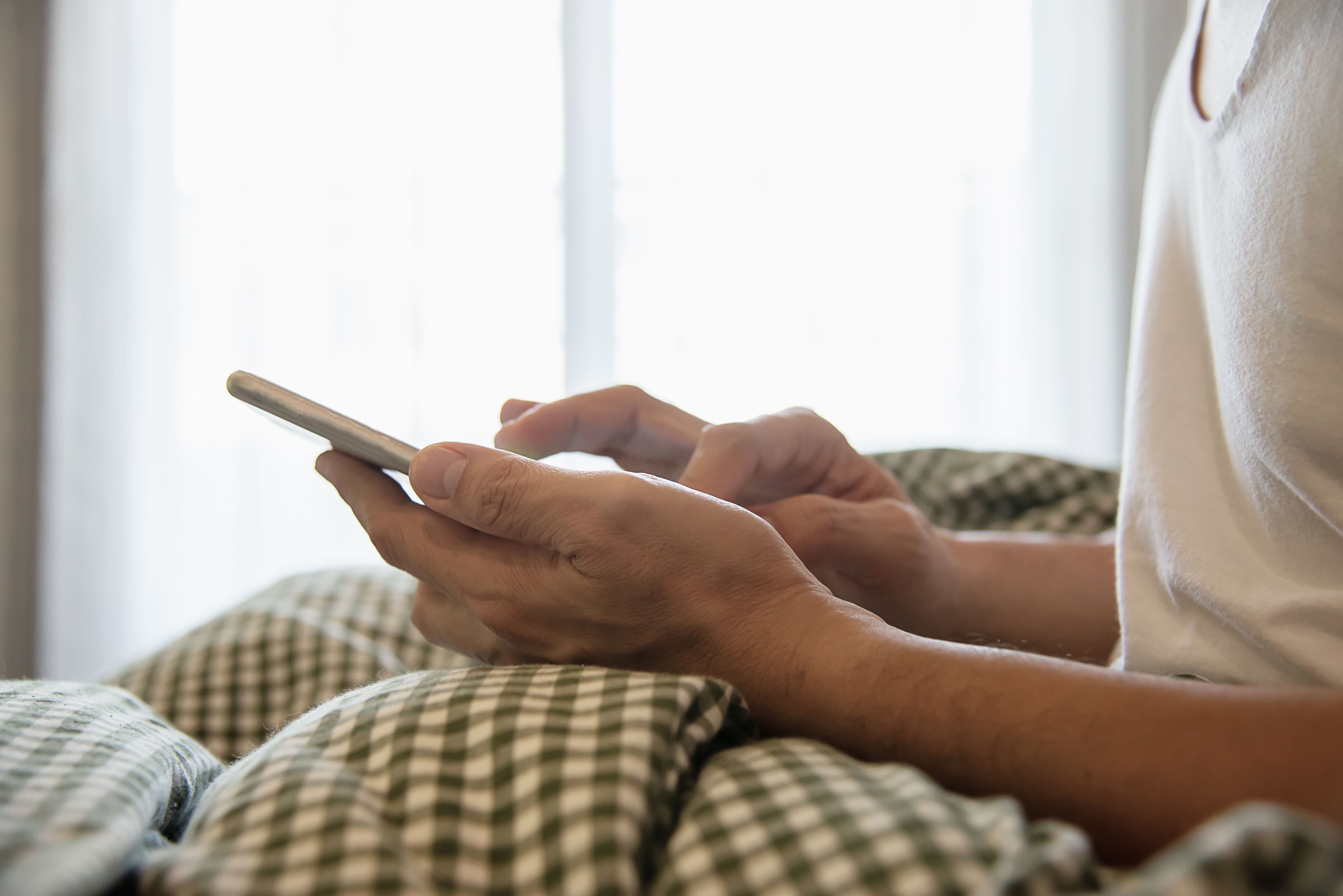 man-using-mobile-phone-while-wake-up-bed.jpg
