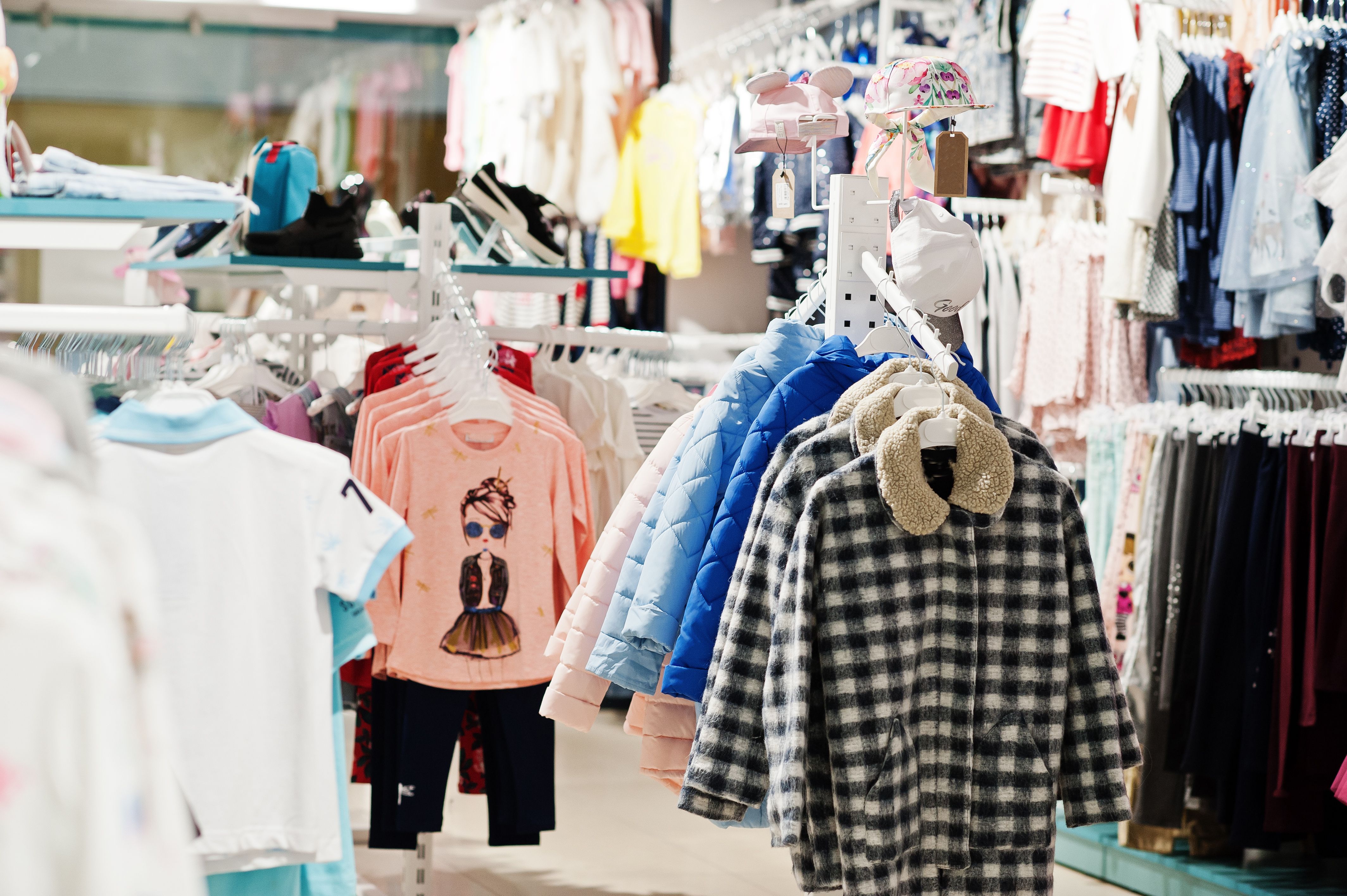 la-ropa-brillante-de-los-ninos-cuelga-en-la-exhibicion-en-la-seccion-de-ninas-de-la-tienda-de-ropa-para-bebes.jpg