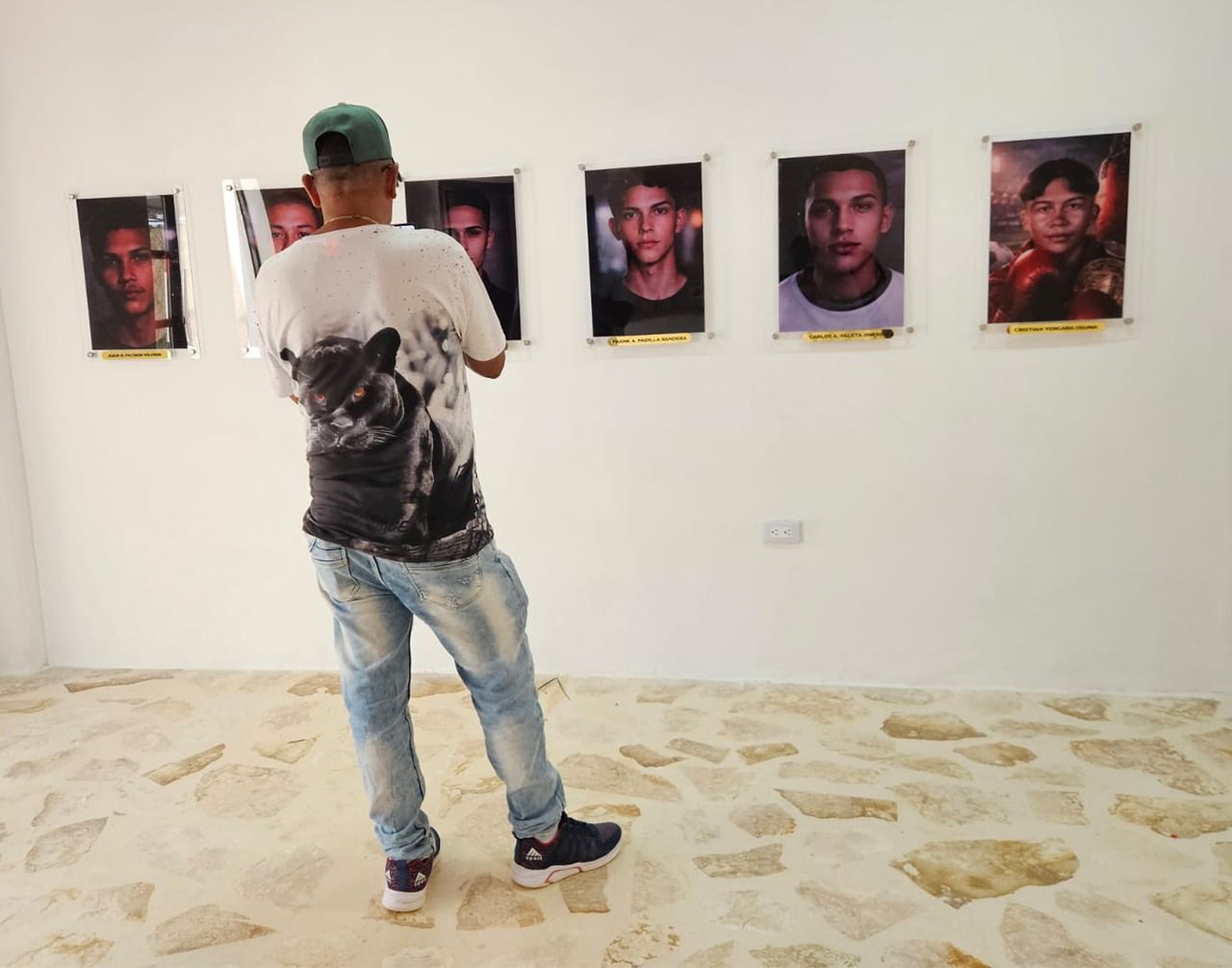Jesús Jiménez Chamo, maestro de obra, hermano de Miguel Enrique Jiménez, cuyo rostro y nombre también están en la sala de la Casa Once en Tolú Viejo, observa los retratos de las víctimas.