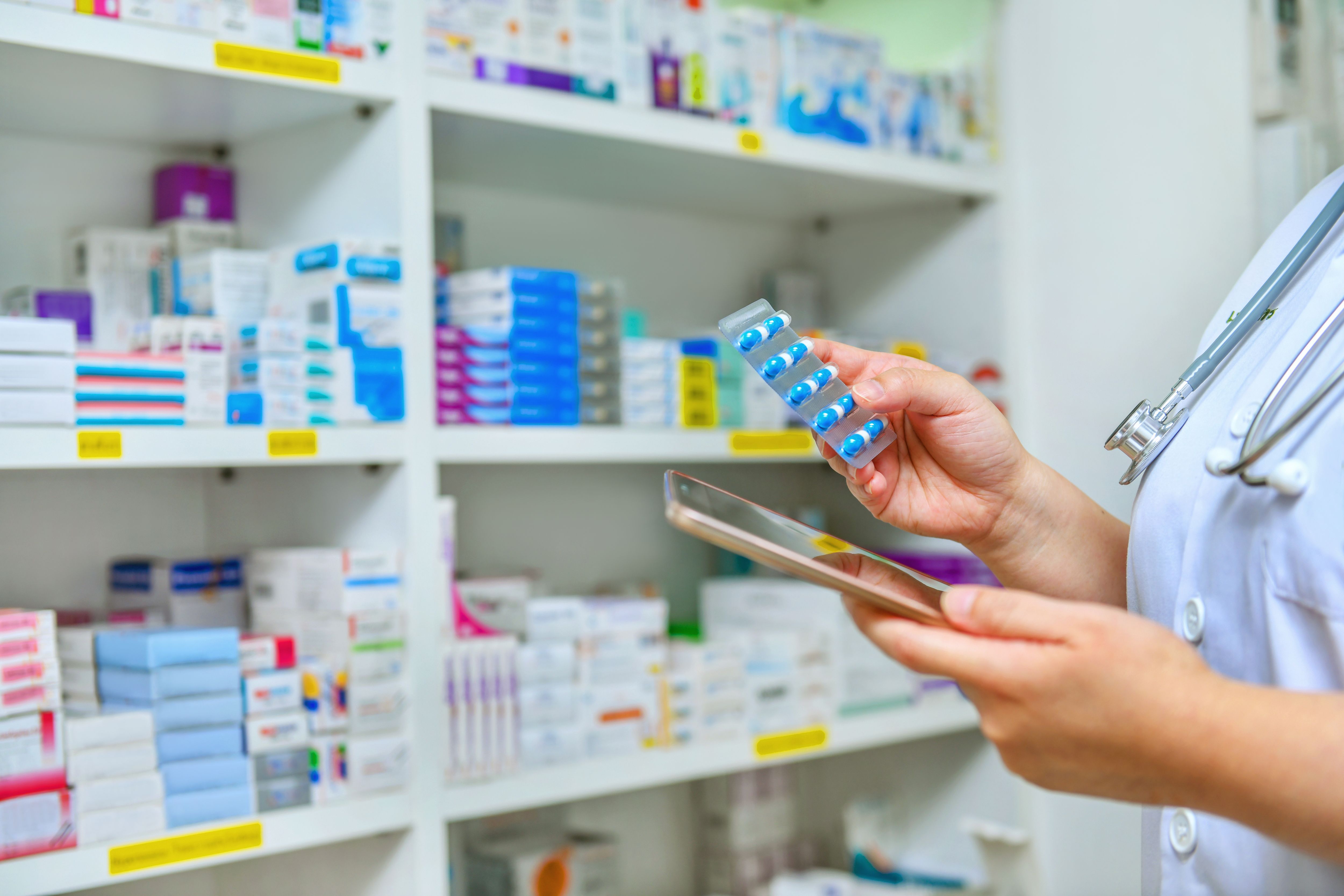 doctor-holding-medicine-capsule-pack-computer-tablet-filling-prescription-pharmacy-drugstore.jpg
