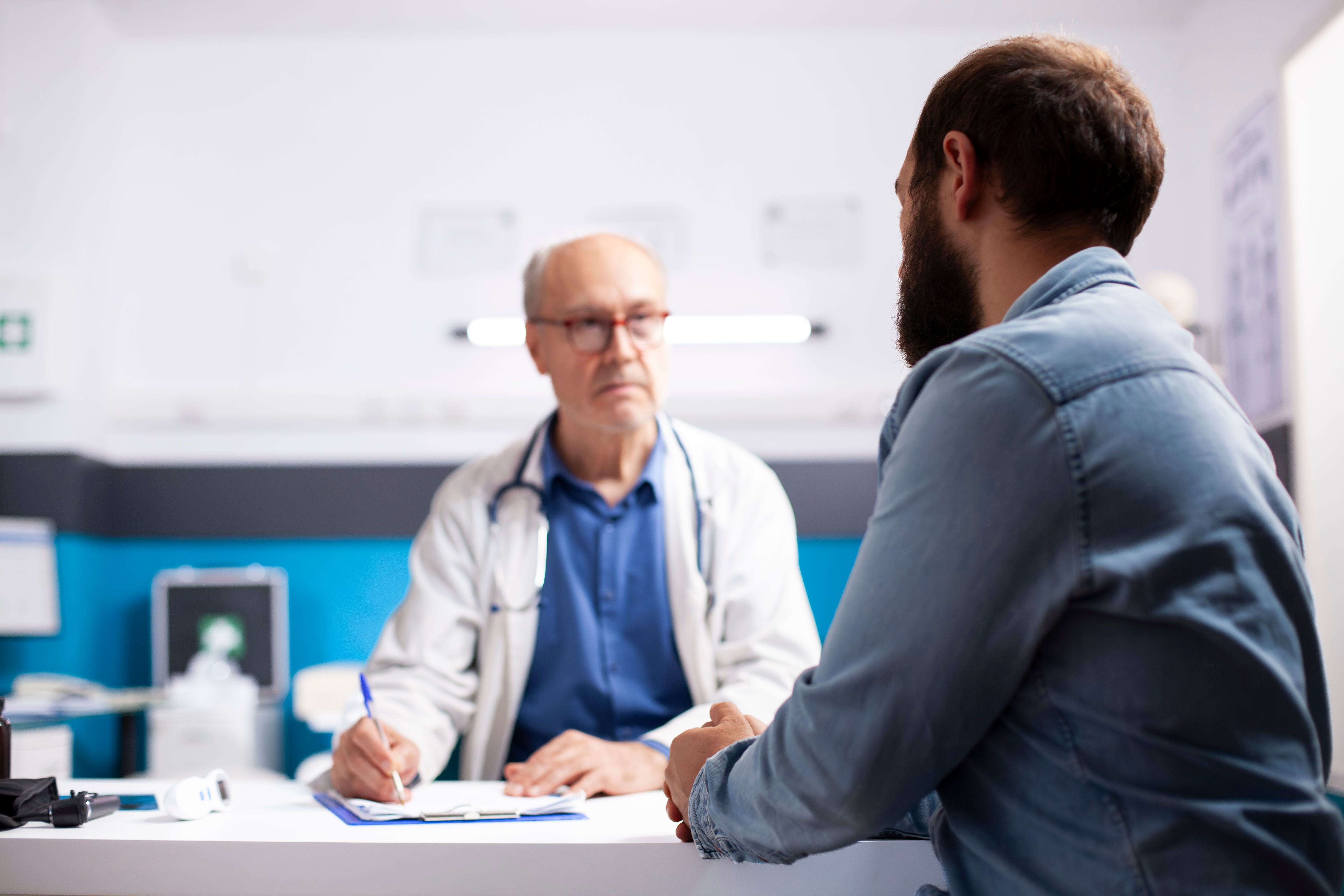 old-physician-listens-man-clinic.jpg