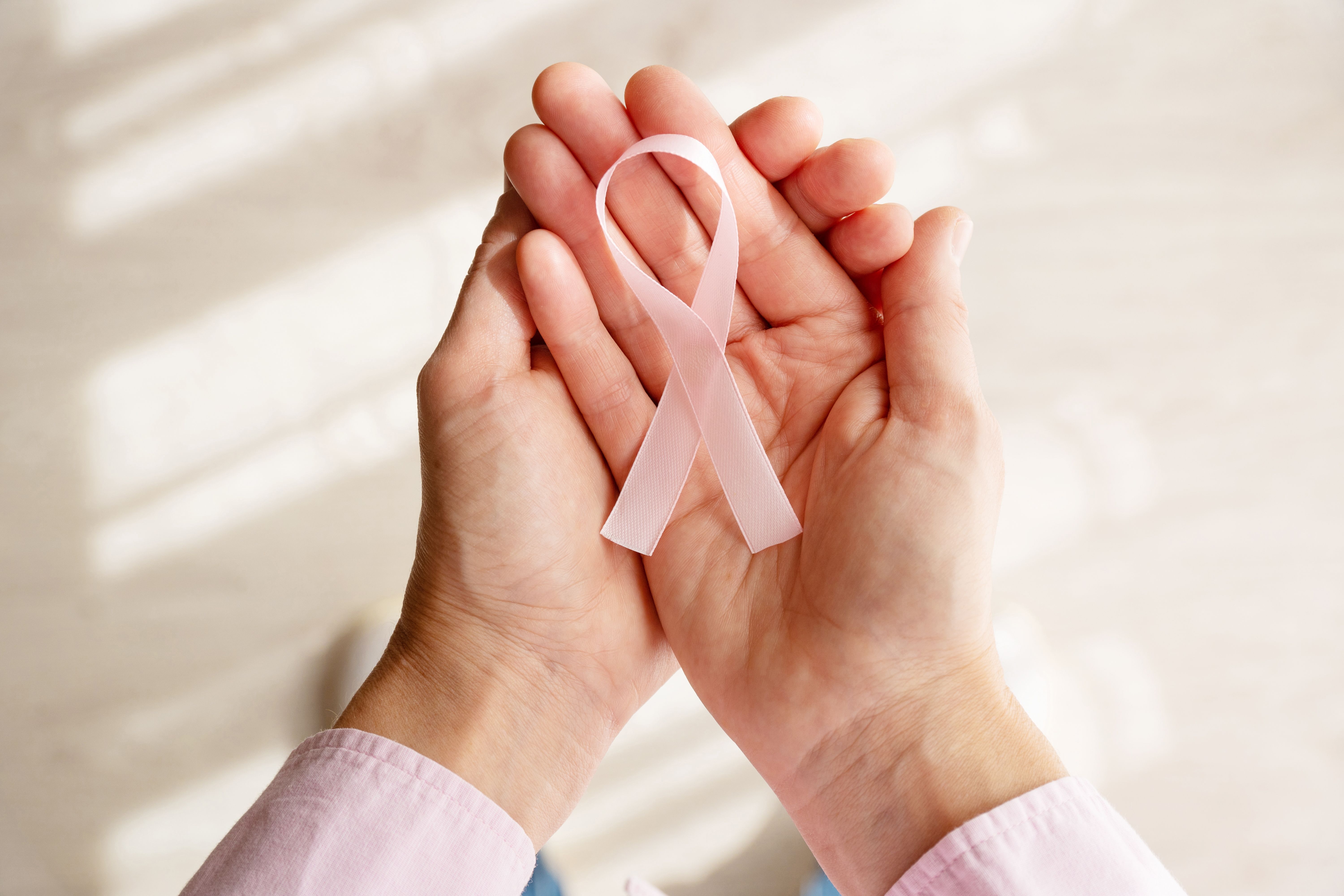 pink-ribbon-against-cancer-hands-woman.jpg